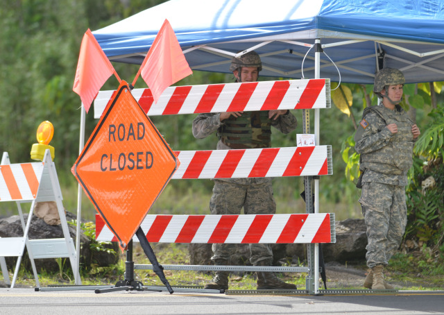 Members from the Task Force Response Army and Air National Guard personnel stand at road block at Pahoa Village Road and Post Office Road only allowing residents that live in the area passage. No media are allowed within this road blocked areas.  30 October 2014. photo Cory Lum