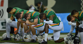 Some UH Hawaii Rainbow Warriors pray in the north end zone before the start of the game against UNLV .  ALOHA STADIUM, HONOLULU, HAWAII. photo CORY LUM/ CIVIL BEAT