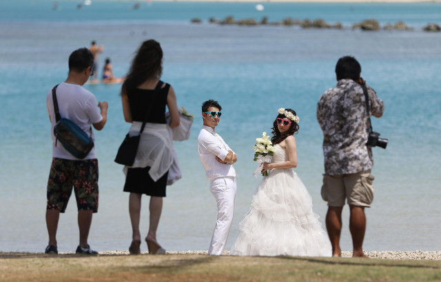 Married couples pose for photographs along the Magic Island side of Ala Moana Beach Park. Mayor Caldwell held a press conference outlining updates to the Ala Moana Beach Master plan. 15 july 2015. photograph Cory Lum/Civil Beat