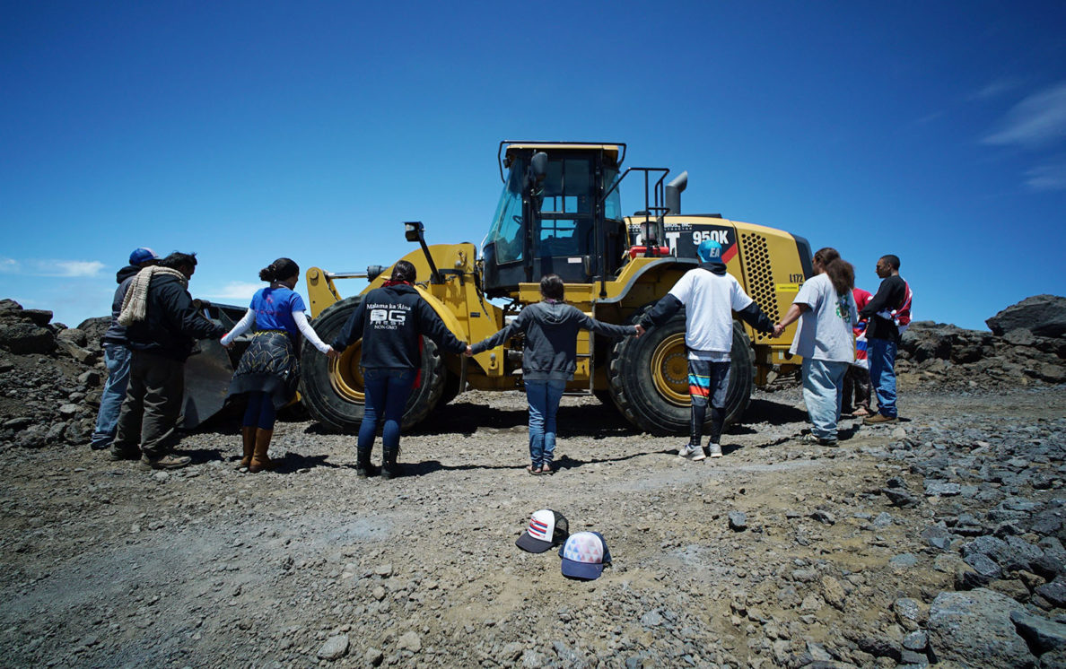 Kahookahi Kunuha leads a small group of supporters near a tractor on the TMT site on the summit of Mauna Kea. 10 april 2015. photograph Cory Lum