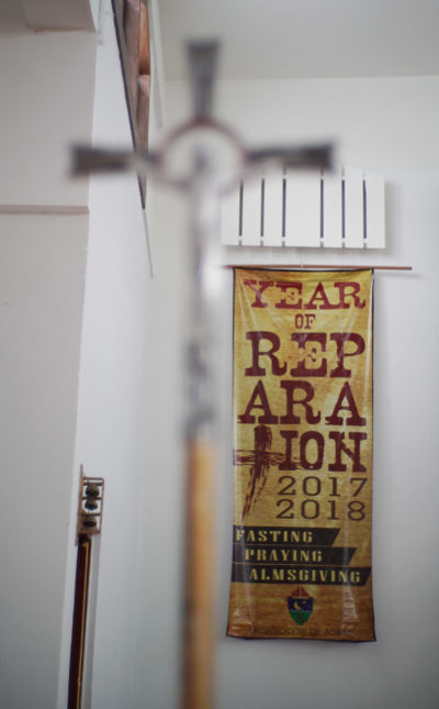 Cross located inside Mount Carmel Church in Hagat, Guam. Church that former Father Anthony Apuron allegely sexually abused Roy Quintanilla and Roland Sandia. Year of Reparation 2017 2017 banner.