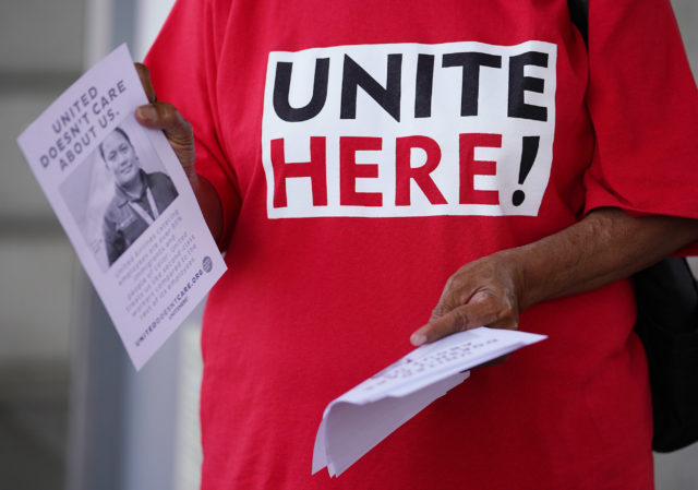 Imaculata Afituk hands out leaflets asking the public for support for United Airlines food workers to unionize at Daniel Inouye International Airport, United curbside area.