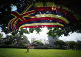 Large Hawaiian Flag flies on mauka side of Thomas Square near Kamehameha III dedication ceremonies held on July 31, also celebrated as Lā Hoʻihoʻi Ea, Sovereignty Restoration Day, an official national holiday of the kingdom of Hawaii.