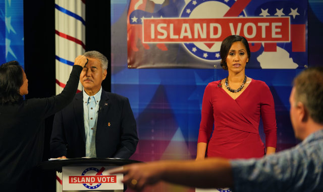 Makeup artist works on Gov David Ige before the iive gubernatorial debate with challenger Andria Tupuola at right.