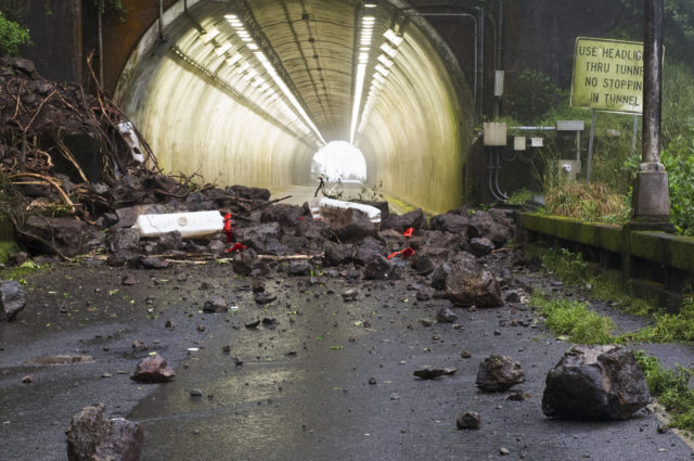 Rocks and debris from a landslide that hit a vehicle are shown on the Pali Highway in Honolulu, Tuesday, Feb. 19, 2019. State transportation officials were assessing the unstable slope above the busy highway after the landslide sent three people to the hospital on Monday. The highway, which connects Honolulu and the east side of Oahu over a steep mountain range, was completely closed and portions will remain shut down all week after multiple landslides in the area. (Craig T. Kojima/Honolulu Star-Advertiser via AP)
