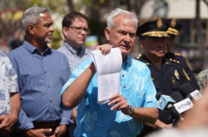 Mayor Kirk Caldwell holds some legal documents during security camera press conference.