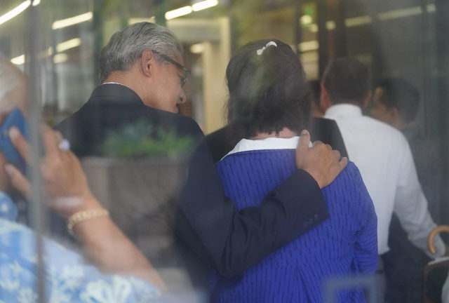Former HPD Chief Louis Kealoha puts his arm on Katherine Kealoha while waiting in the line to go through security outside District Court.