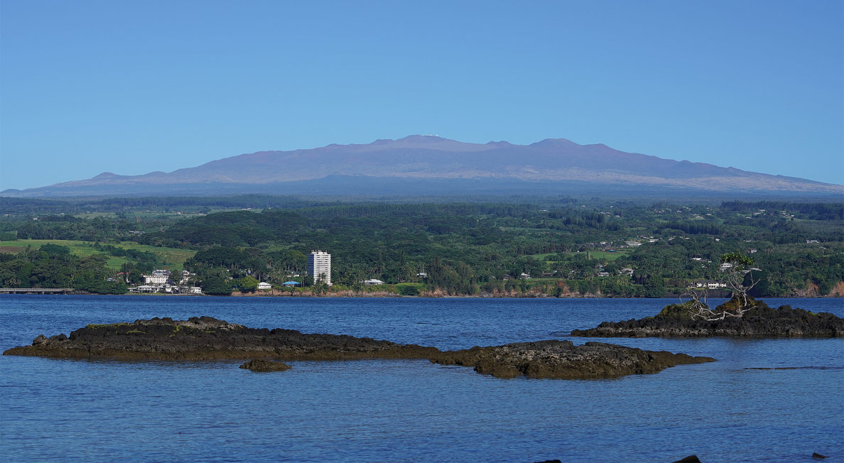 TMT Hilo waterfront with the TMT Mauna Kea Observatories. The tiny white dots on the top of Mauna Kea are the observatories.
