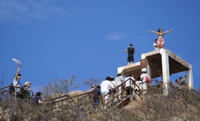 Visitors disregard ‘Keep Off’ signs and stand on top the Diamond Head Summit lookout bunker.