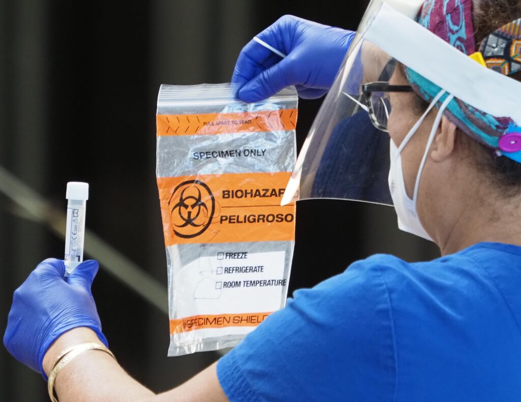 A medical technician displays how to prepare a COVID-19 swab sample during a testing event at the Blaisdell Center in Honolulu, HI, Monday, November 30, 2020. (Ronen Zilberman photo Civil Beat)