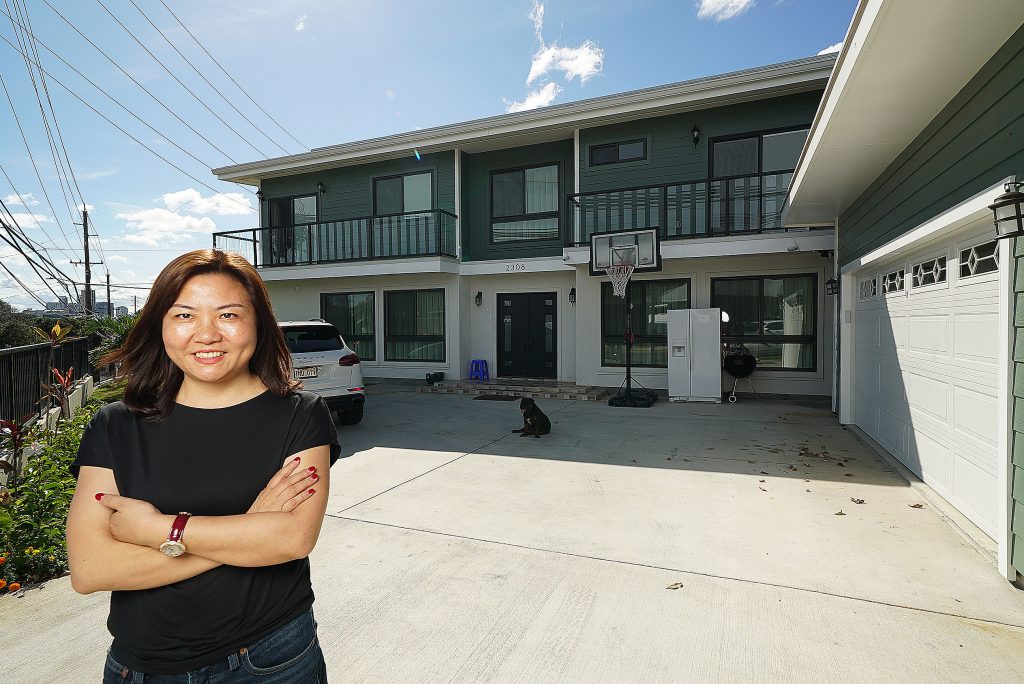 Christy Zeng Lei stands fronting one of houses she owns located at 2308 Dole Street.