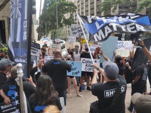 HPD supporters and protestors face each other outside the court in Honolulu Tuesday, July 20, 2021, where a preliminary hearing took place for the three officers in connection with the April 5 fatal shooting of a 16-year-old who was at the wheel of a stolen car that had allegedly been involved in a violent crime spree(Ronen Zilberman photo Civil Beat)