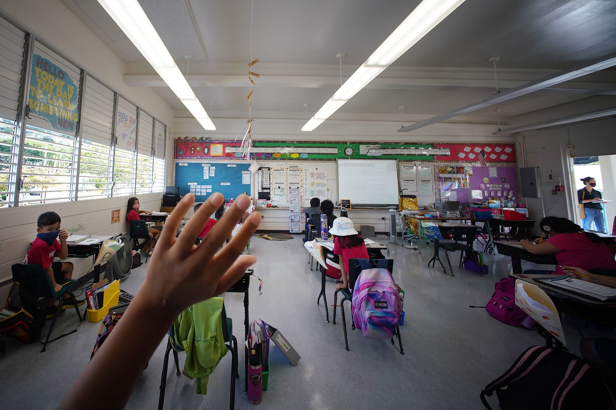 A student in Pauoa Elementary School 3rd grade Teacher Kristin Tatemichi class raises their hand during a lesson.