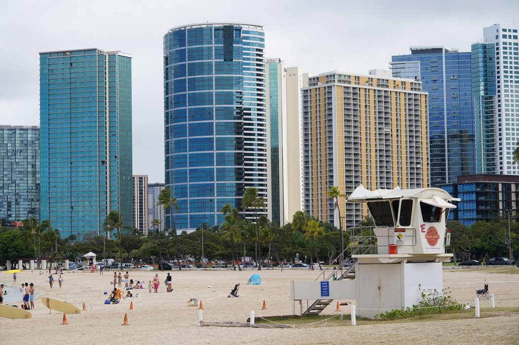 Kakaako condominiums tower over the lifeguard towers located at Ala Moana Beach Park.