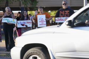 Waianae High School principal Ray Pikelny-Cook, second from right, wearing orange, waves to a car dropping off a student on First Friday promoting the month of Unity Friday, Oct. 6, 2023, in Waianae. National Unity Day is Oct. 18, but the west Oahu school celebrates it for the entire month. They will promote inclusion and community and denounce bullying. This month’s First Friday theme serendipitously with the cancelation of the school’s football game against Castle High School for the safety of students, athletes and community members. (Kevin Fujii/Civil Beat/2023)
