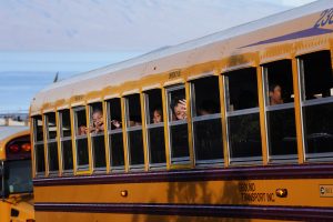 A bus of elementary school students celebrate their return to studying in Lahaina Wednesday, Oct. 18, 2023. Princess Nahienaena Elementary School opened their campus for King Kamehameha III Elementary School to place temporary classrooms. The schools have been closed since the Aug. 8 fire and studying at other schools in Maui. King Kamehameha III Elementary School was destroyed in the blaze. (Kevin Fujii/Civil Beat/2023)