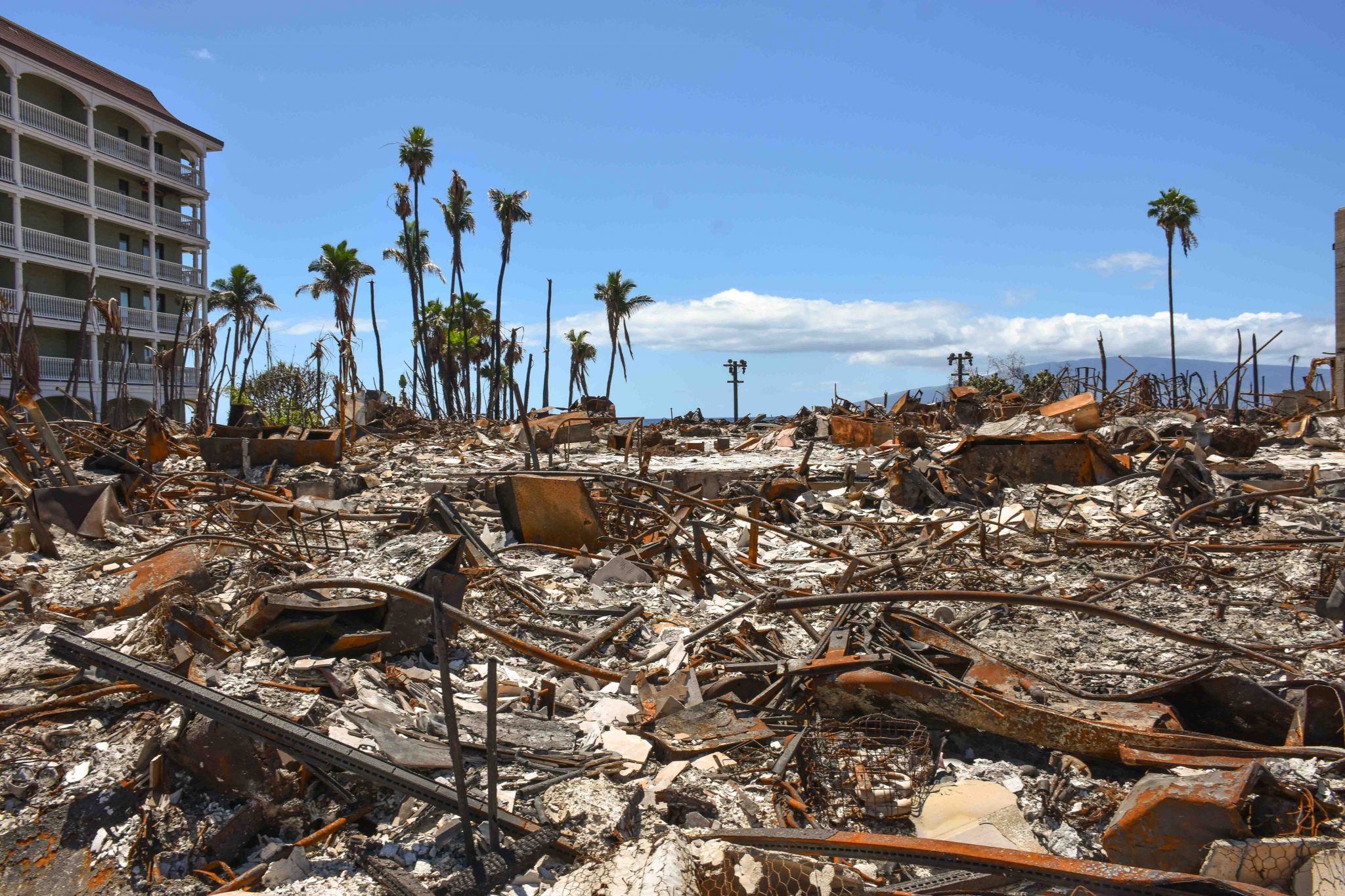 One of the trickiest commercial buildings to clear of fire debris is 505 Front St., which includes a flooded underground garage and is next to a surviving building, Lahaina Shores Beach Resort. (Cammy Clark/Civil Beat/2024)