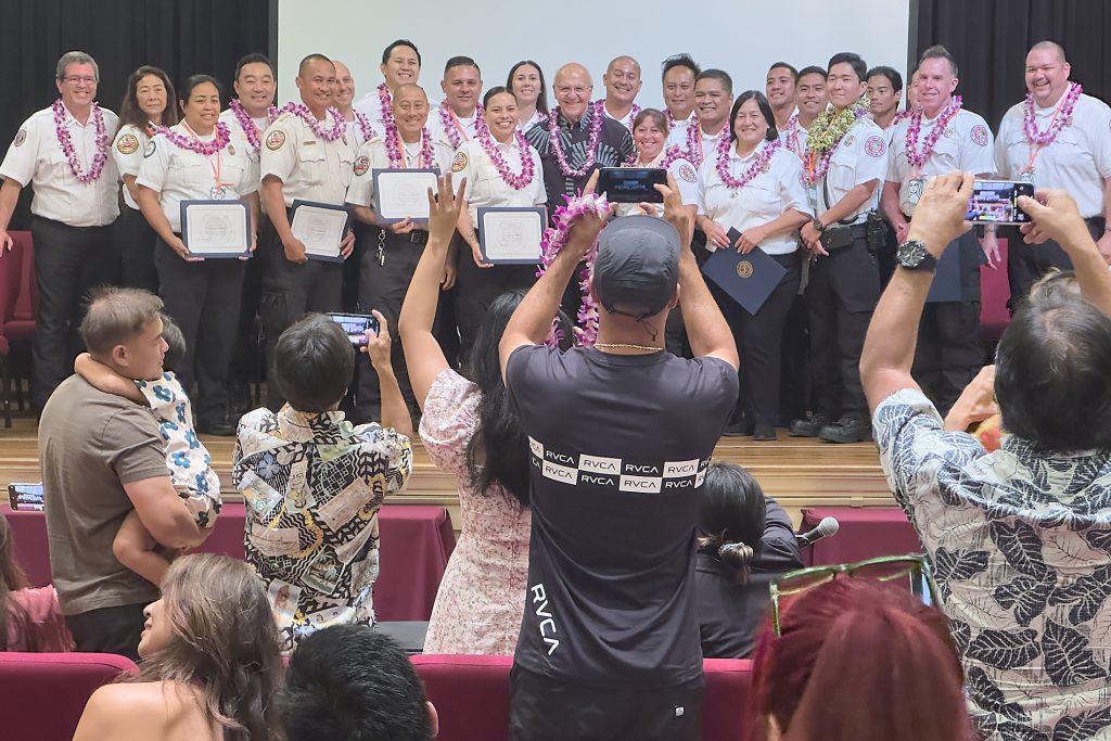Proud parents and friends stand to photograph their promoted relatives following a first-of-its-kind promotion that took place 10 a.m. May 20 at Mission Memorial Auditorium to honor all current Honolulu Emergency Medical Service field operation supervisors (district chiefs) and unit supervisors. (David Croxford/Civil Beat/2024)