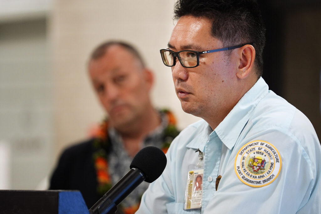 Department of Agriculture plant quarantine inspector Jonathan Ho speaks during the news briefing for digitizing the Hawaiʻi Department of Agriculture’s plant and animal declarations Monday, Feb. 24, 2025, at Daniel K. Inouye International Airport in Honolulu. This will help reduce manpower required to read and asses the paper forms travelers arriving in Hawaiʻi fill out on airplanes. (Kevin Fujii/Civil Beat/2025)