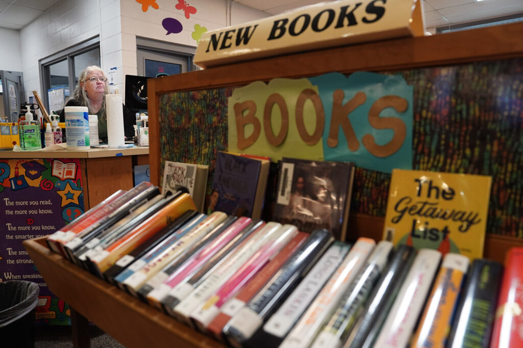 The New Books display blocks a Waiākae High School student talking story with librarian Leslie Fukushima Monday, March 10, 2025, in Hilo. (Kevin Fujii/Civil Beat/2025)