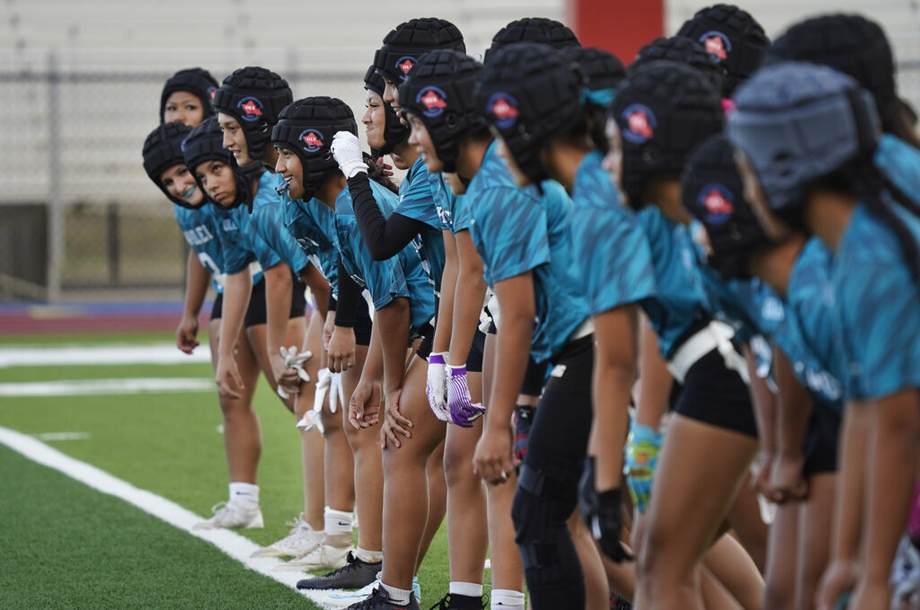 Joyful smiles spread across Kapolei High School girls flag football players faces even for running sprints before taking on Dreamhouse Nā Hōkū in the first Hawai’i girls high school flag football game Tuesday, March 25, 2025, at Wai’anae High School in Wai’anae. (Kevin Fujii/Civil Beat/2025)
