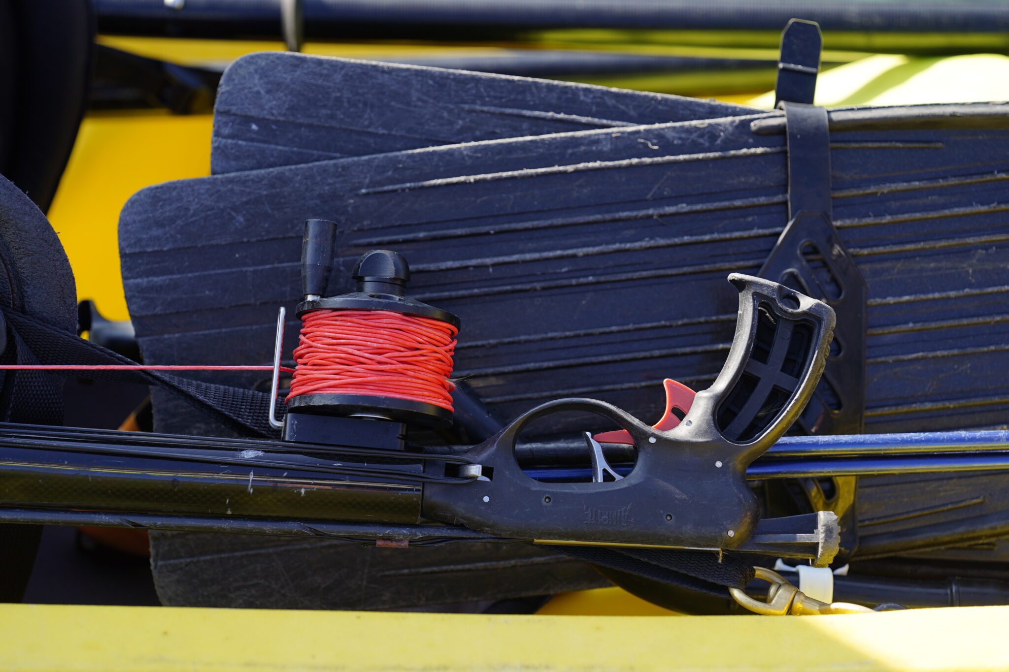A speargun and fins sit inside a kayak at Nāpōʻopo‘o Wharf to compete in the Kealakekua Bay Non-Native I‘a (fish) Removal Event Sunday, May 18, 2025, in Captain Cook. Spearfishing has been banned in the Marine Life Conservation District since 1969. Numerous groups worked with state and local agencies for a special permit to close the bay to other aquatic activities and tourism for the morning. (Kevin Fujii/Civil Beat/2025)