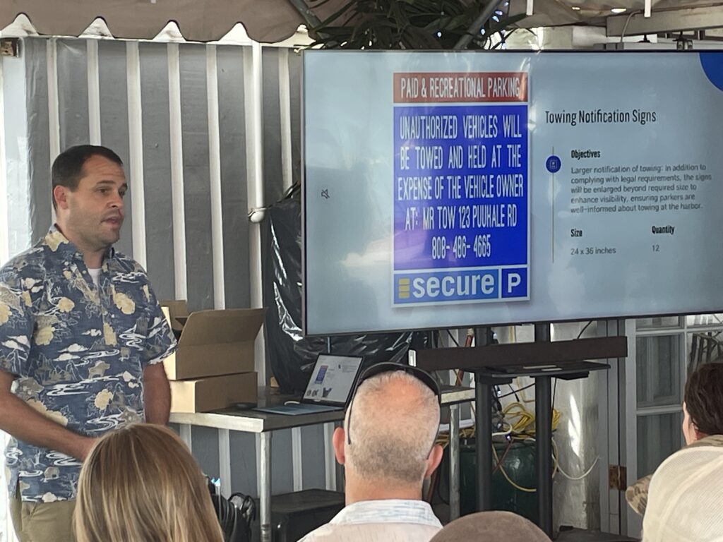 General Manager of Secure Parking Jonathan Alexander presenting concepts of new enforcement signs the company is planning to install at the Ala Wai Boat Harbor.