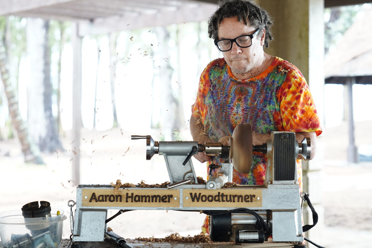 Milo-wood shavings fly off the exterior of a bowl beginning to take shape on woodturner Aaron Hammer’s mobile woodturning studio Wednesday, July 2, 2025, in Kailua. (Kevin Fujii/Civil Beat/2025)