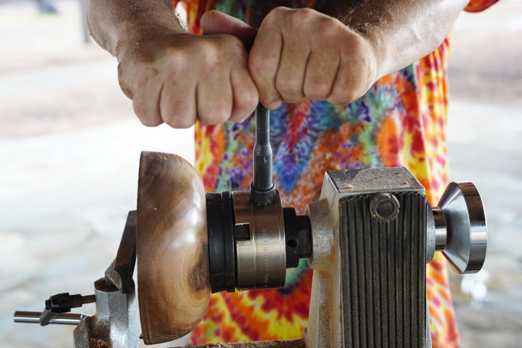 Woodturner Aaron Hammer tightens a chuck for jaws to firmly grasp the foot of a wooden bowl Wednesday, July 2, 2025, in Kailua. (Kevin Fujii/Civil Beat/2025)