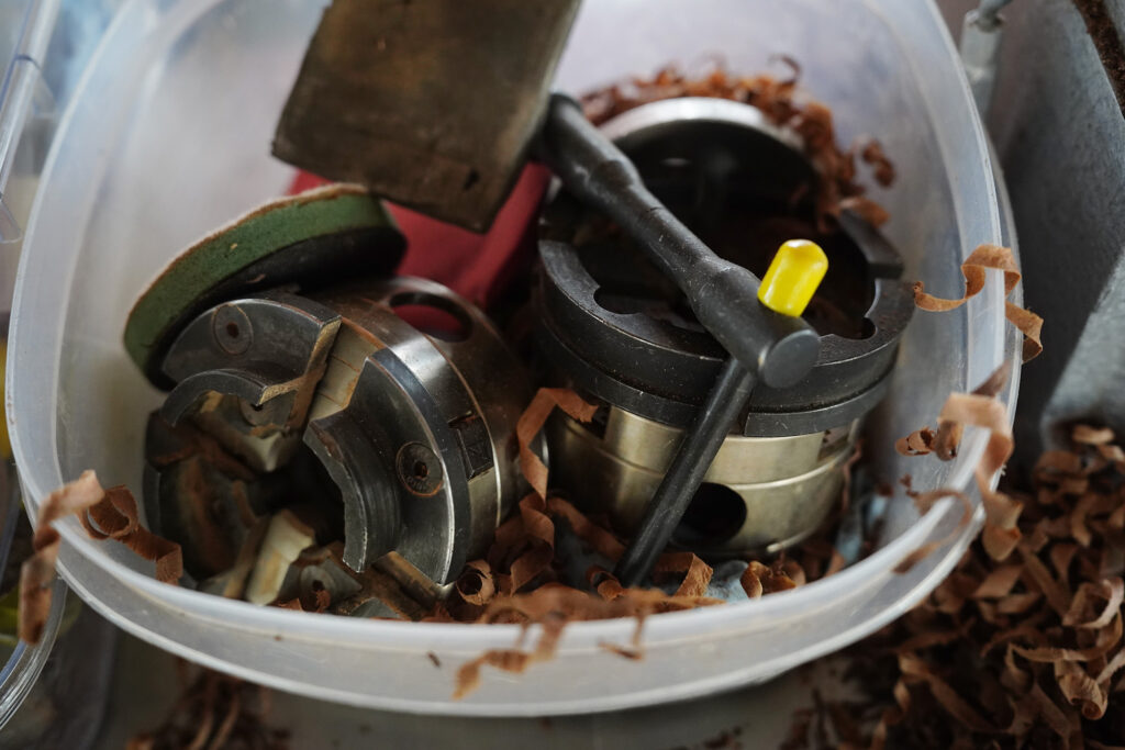 Wood shavings find their way into woodturner Aaron Hammer’s container of lathe chucks and jaws after making a new milo-wood bowl Wednesday, July 2, 2025, in Kailua. (Kevin Fujii/Civil Beat/2025)
