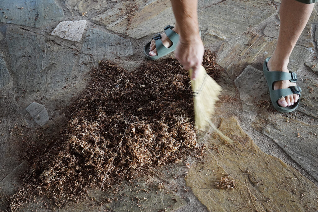 Woodturner Aaron Hammer sweeps up wood shavings from milo wood Wednesday, July 2, 2025, in Kailua. (Kevin Fujii/Civil Beat/2025)