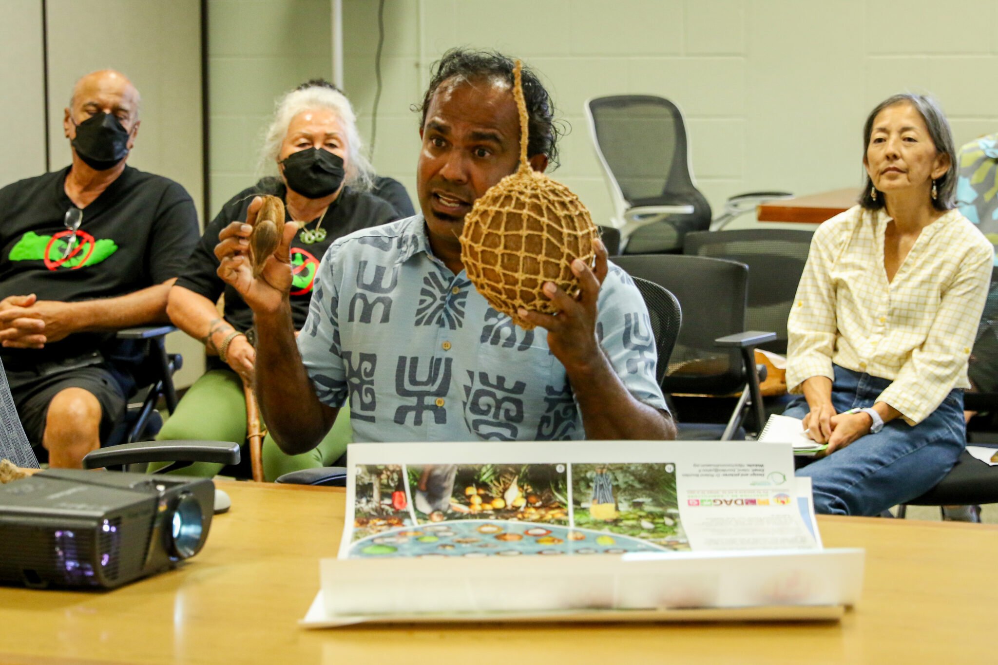 Indrajit Gunasekara, Director of Community Coconut Projects for Kaulunani Urban Forestry Program demonstrates Hawaiian coconut variety before the Board of Agriculture and Biosecurity. (Leilani Combs/Civil Beat/2025)