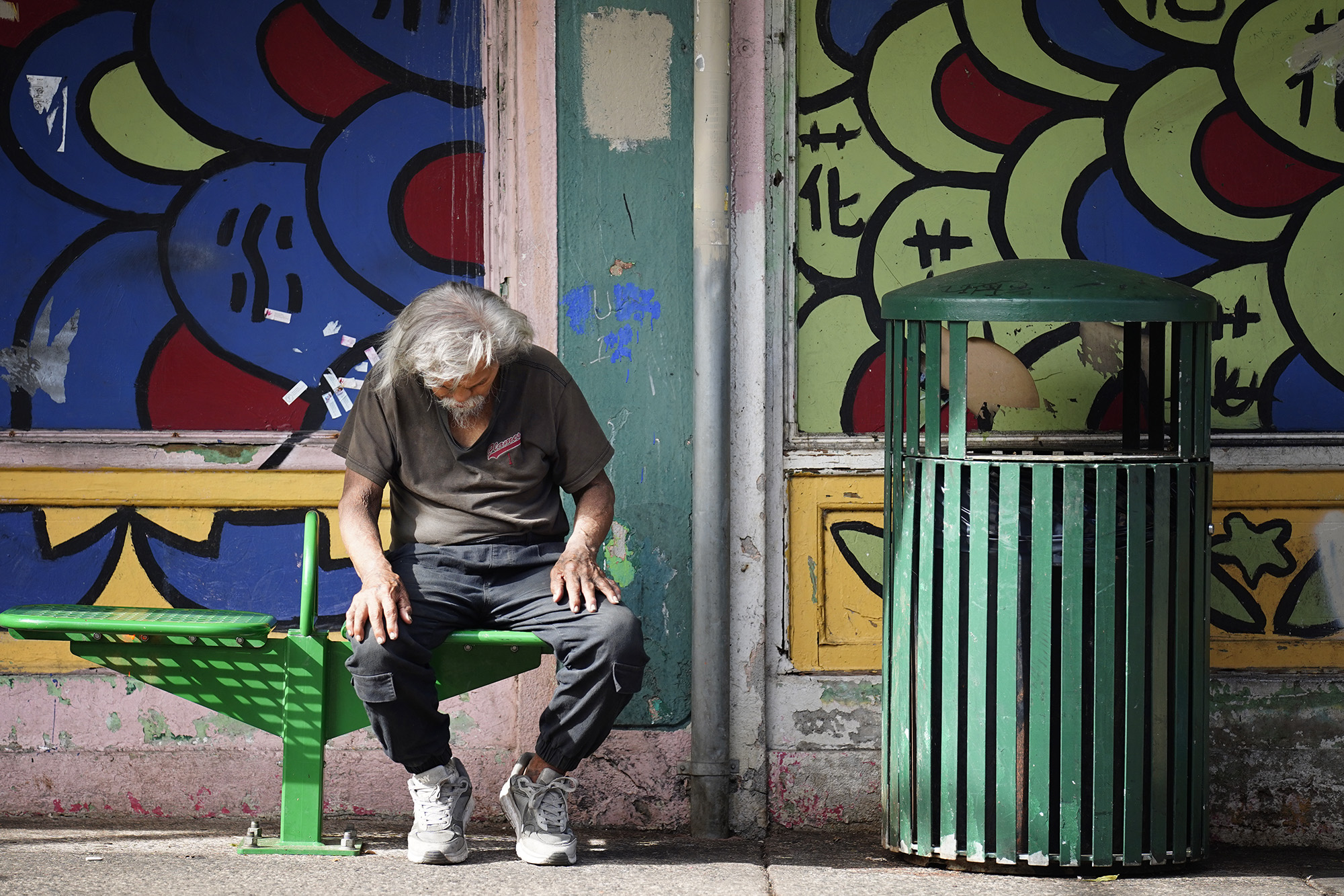 Orlando Javierto sits at a bus stop in Chinatown Friday, Oct. 16, 2025, in Honolulu. (Kevin Fujii/Civil Beat/2025)