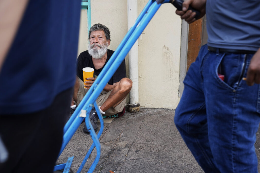 Tristan Martinez watches passsers-by Friday, Oct. 16, 2025, in Honolulu’s Chinatown. Martinez is homeless and stays on the streets in Chinatown. (Kevin Fujii/Civil Beat/2025)