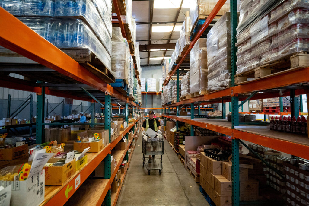 Volunteer Henry Battjes picks up groceries for distribution at The Pantry by Feeding Hawaii Together, Monday, Nov. 10, 2025, in Honolulu. (AP Photo/Mengshin Lin)