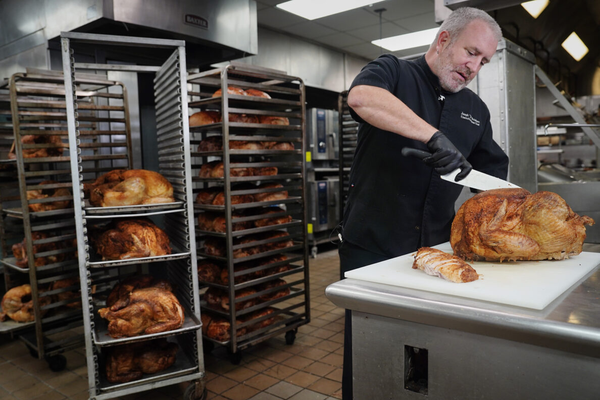 Hilton Hawaiian Village Executive Sous Chef Joseph “JJ” Reinhart slices a turkey breast for part of the 450 Thanksgiving meals Tuesday, Nov. 25, 2025, in Honolulu. This marks the 30th year the hotel kitchen donates to the Institute for Human Services (IHS). (Kevin Fujii/Civil Beat/2025)