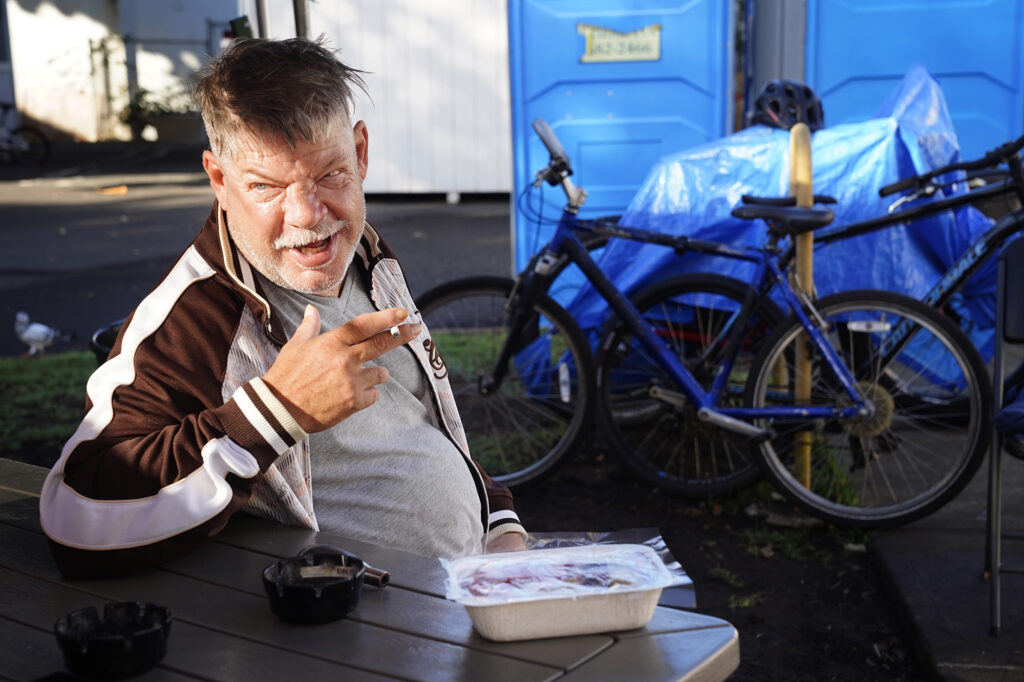 Aaron Lapham works on finishing his cigarette before breakfast at the A‘ala Respite Center Monday, Dec. 8, 2025, in Honolulu. The former bank building turned medical facility is attached to a kauhale to help homeless get well and back on their feet. (Kevin Fujii/Civil Beat/2025)