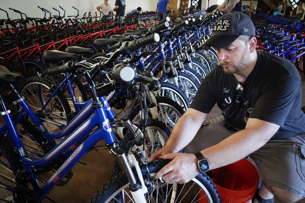 Ryan Pierce of Stockton, Calif., checks for loose bolts on a linear-pull brake caliper during a Jim Falk annual Christmas Kids Bike Build Saturday, Dec. 6, 2025, in Puʻunēnē. Approximately 450 new bicycles are built and distributed in Maui County. (Kevin Fujii/Civil Beat/2025)