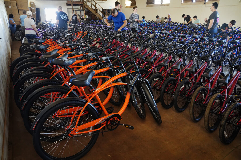 Volunteers work during one of four Jim Falk’s annual Christmas Kids Bike Build days takes place Saturday, Dec. 6, 2025, in Puʻunēnē. Approximately 450 new bicycles are built and will distributed to keiki in Maui County. (Kevin Fujii/Civil Beat/2025)