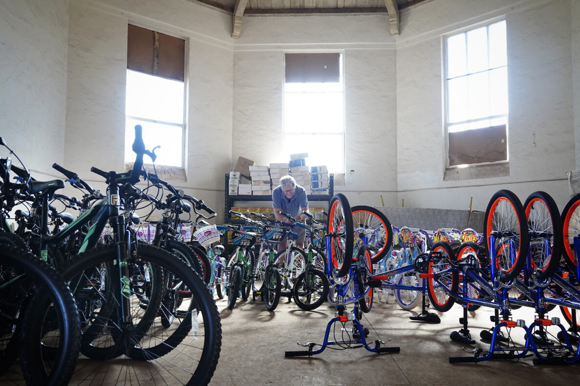 Volunteer Paul Pyzyna of Makawao, checks for loose threaded headsets during one of Jim Falk’s annual Christmas Kids Bike Build days Saturday, Dec. 6, 2025, in Puʻunēnē. Pyzyna has been volunteering a few years to build bikes for Maui County keiki. “My heart comes up to my throat,” Pyzyna said. “I’m always on the verge of tears,” he said about volunteering. (Kevin Fujii/Civil Beat/2025)