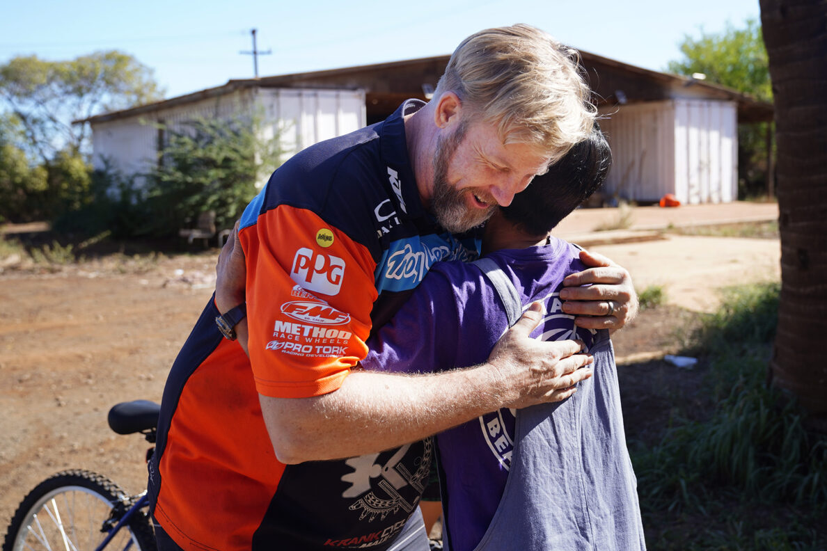 Krank Cycles Maui owner Aaron ”Moose" Reichert gets a hug from Mayumi Oshima during one of Jim Falk’s annual Christmas Kids Bike Build days Saturday, Dec. 6, 2025, in Puʻunēnē. Oshima and her family received new bikes and helmets for their volunteerism with the bike build and their church. (Kevin Fujii/Civil Beat/2025)