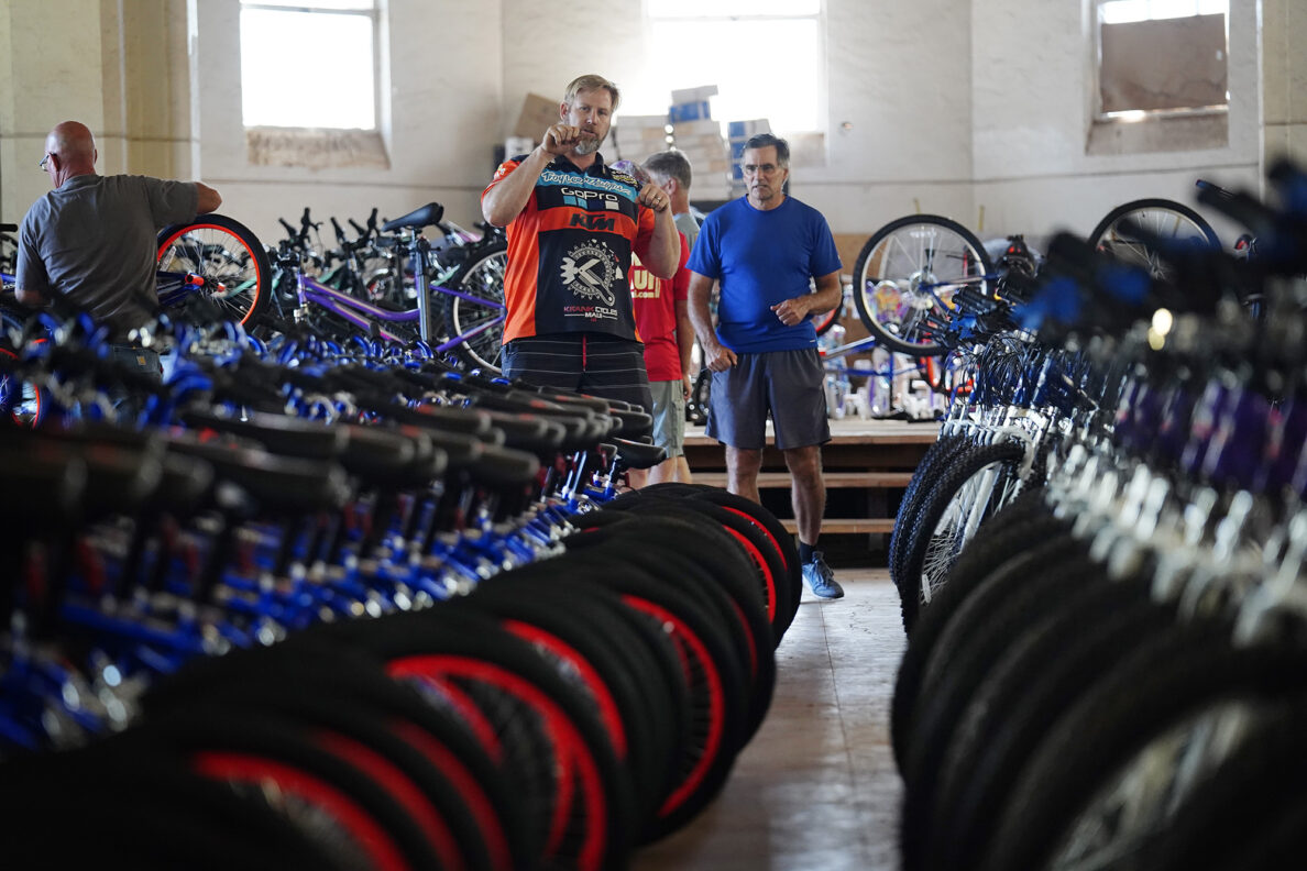 Krank Cycles Maui owner Aaron ”Moose" Reichert, left, and first-year volunteer Mike McKenna of Māʻalaea chat about spacing the bikes during one of Jim Falk’s annual Christmas Kids Bike Build days Saturday, Dec. 6, 2025, in Puʻunēnē. McKenna learned about the volunteer opportunity on social media. (Kevin Fujii/Civil Beat/2025)
