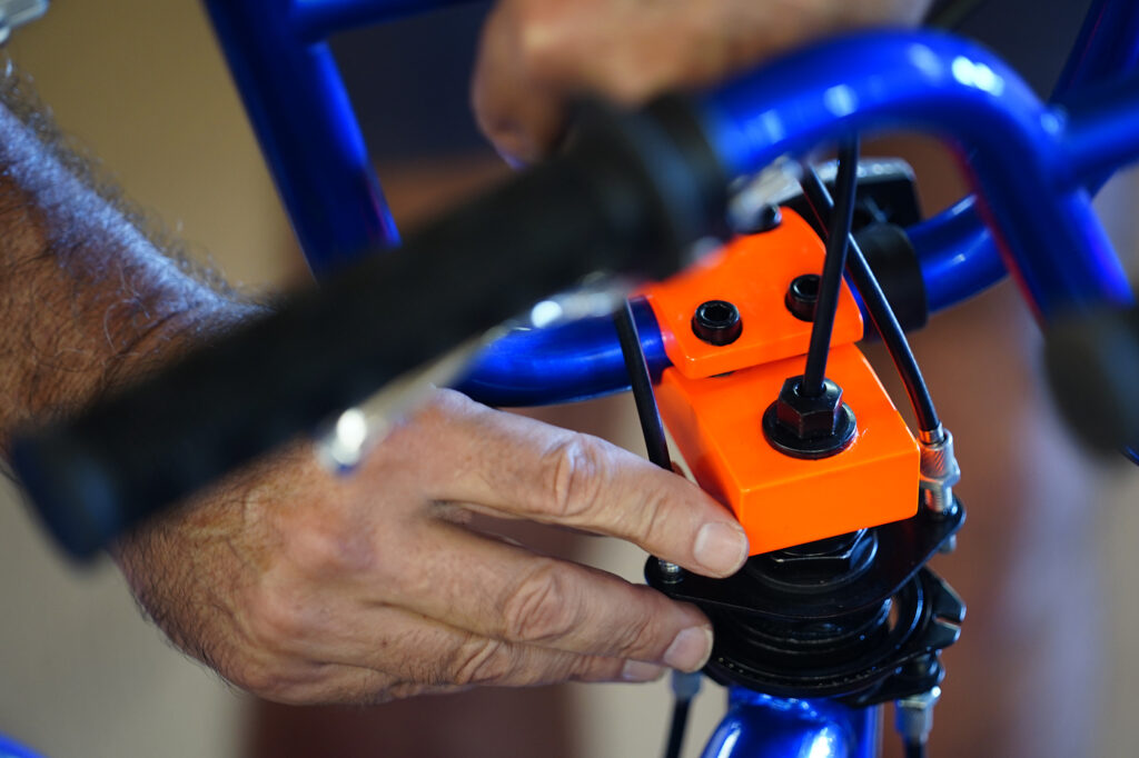 Mike McKenna of Māʻalaea tightens brake cables during one of Jim Falk’s annual Christmas Kids Bike Build days Saturday, Dec. 6, 2025, in Puʻunēnē. (Kevin Fujii/Civil Beat/2025)