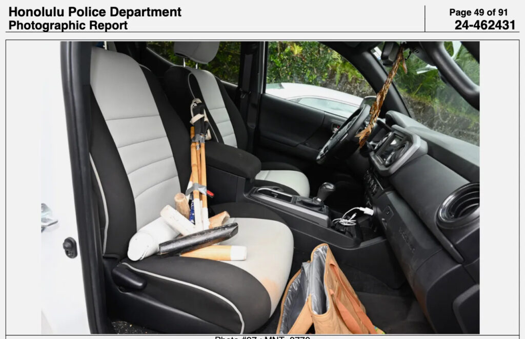 A bundle of wooden mallets with long heads on the passenger seat of a car with a black-and-white interior.