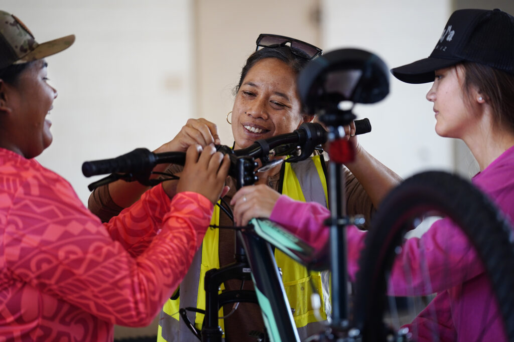 Bayer employees Ambrosialynn Casil-Dudoit, from left, Iponohea Nahoopii-Kaauwai and Keeya Bicoy attach handlebars onto a bike during Jim Falk’s annual Christmas Kids Bike Build Wednesday, Dec. 10, 2025, in Kaunakakai, Molokaʻi. Approximately 450 new bicycles are built and will distributed to keiki in Maui County. (Kevin Fujii/Civil Beat/2025)