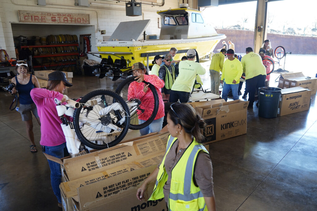 Bayer employees build bikes at the Kaunakakai Fire Station for Jim Falk’s annual Christmas Kids Bike Build Wednesday, Dec. 10, 2025, on Molokaʻi. Approximately 450 new bicycles are built and will distributed to keiki in Maui County. (Kevin Fujii/Civil Beat/2025)