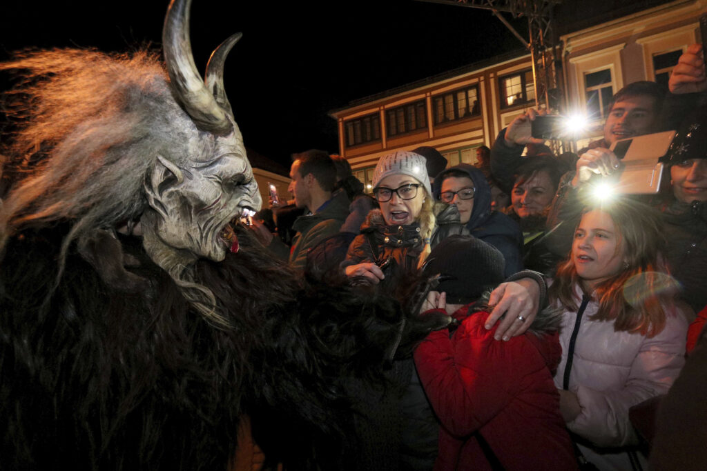 A man dressed as Krampus scares spectators during a Krampus run in Hollabrunn, Austria, Saturday, Nov. 25, 2017. (AP Photo/Ronald Zak)