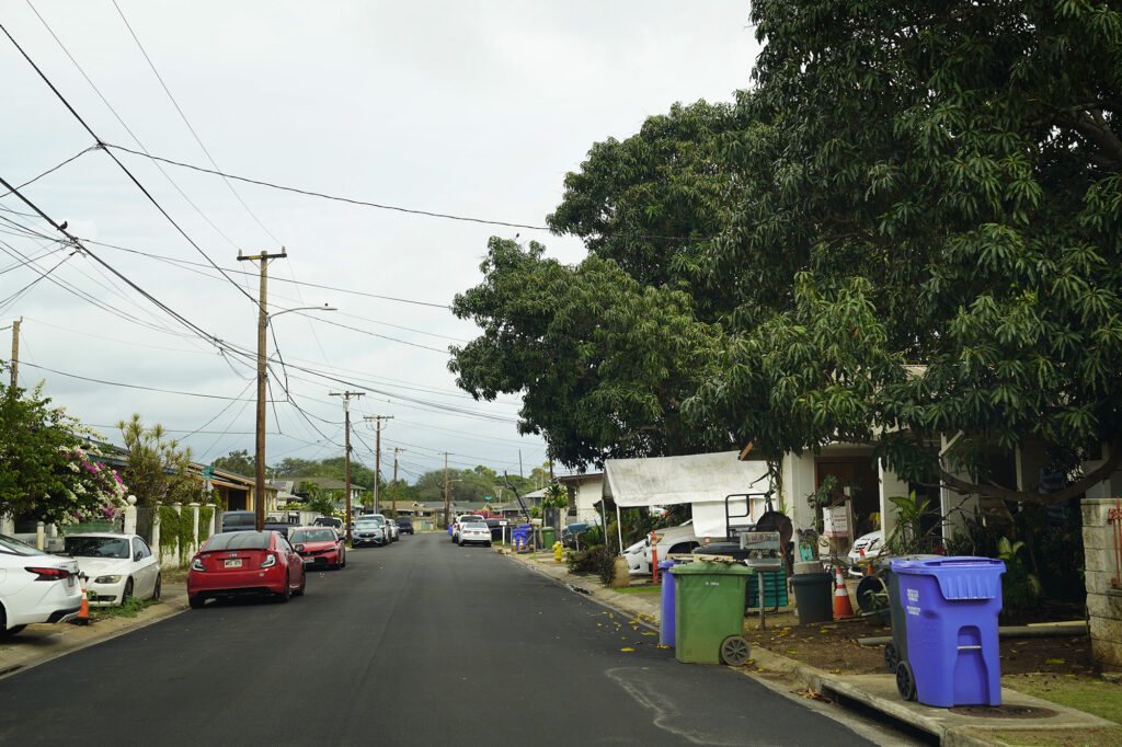 Residents of an ʻEwa Beach neighborhood park their vehicles, recycling and compost bins where sidewalks are usually placed Monday, Dec. 15, 2025. This is Imelda Street. (Kevin Fujii/Civil Beat/2025)