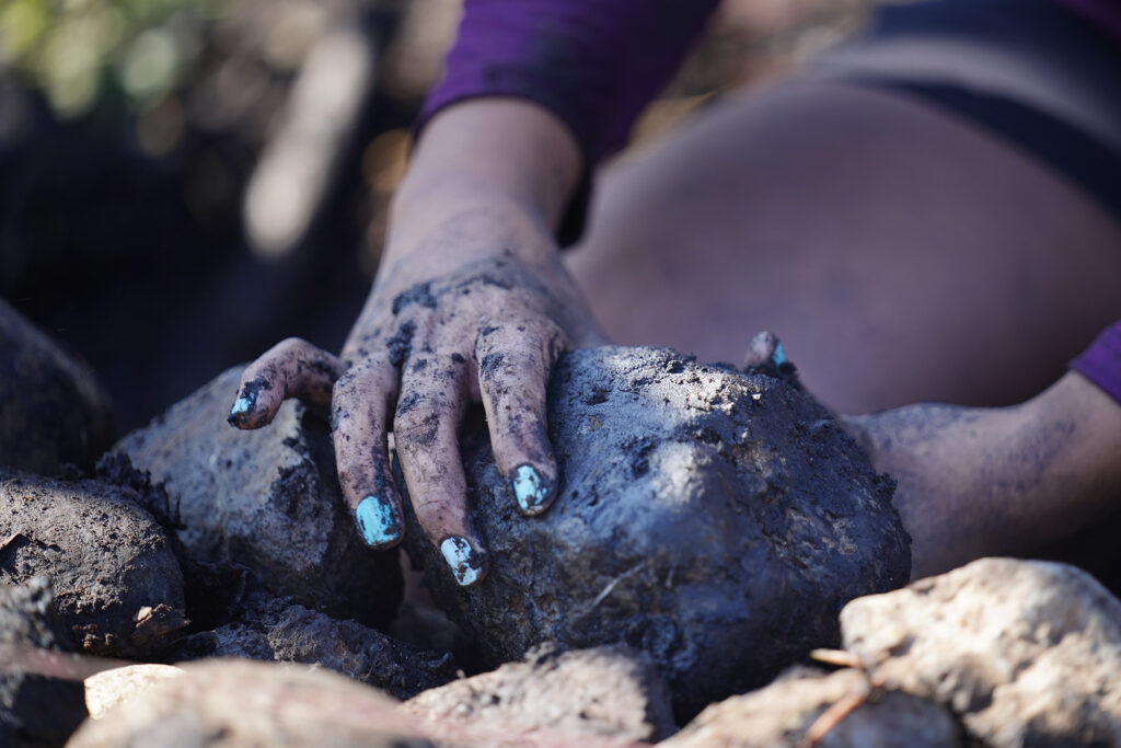 Moʻokuapā volunteer Nākai‘elua Villatora of Kauaʻi sets stones along between a ditch and the new He‘eia Loko I‘a wall Saturday, Dec. 13, 2025, in Kāneʻohe. 2,000 volunteers joined the Moʻokuapā community work day to finish the wall of the 800-year-old He‘eia loko i‘a (fishpond). (Kevin Fujii/Civil Beat/2025)