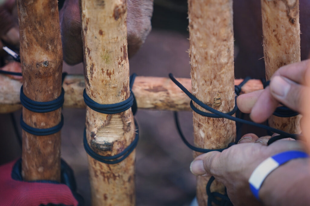 A new mākāhā (sluice gate placed between wai (fresh water) outlet and kai (salt water) is lashed together during the Moʻokuapā event at He‘eia Loko I‘a Saturday, Dec. 13, 2025, in Kāneʻohe. 2,000 volunteers joined the Moʻokuapā community work day to finish the wall of the 800-year-old He‘eia loko i‘a (fishpond). (Kevin Fujii/Civil Beat/2025)
